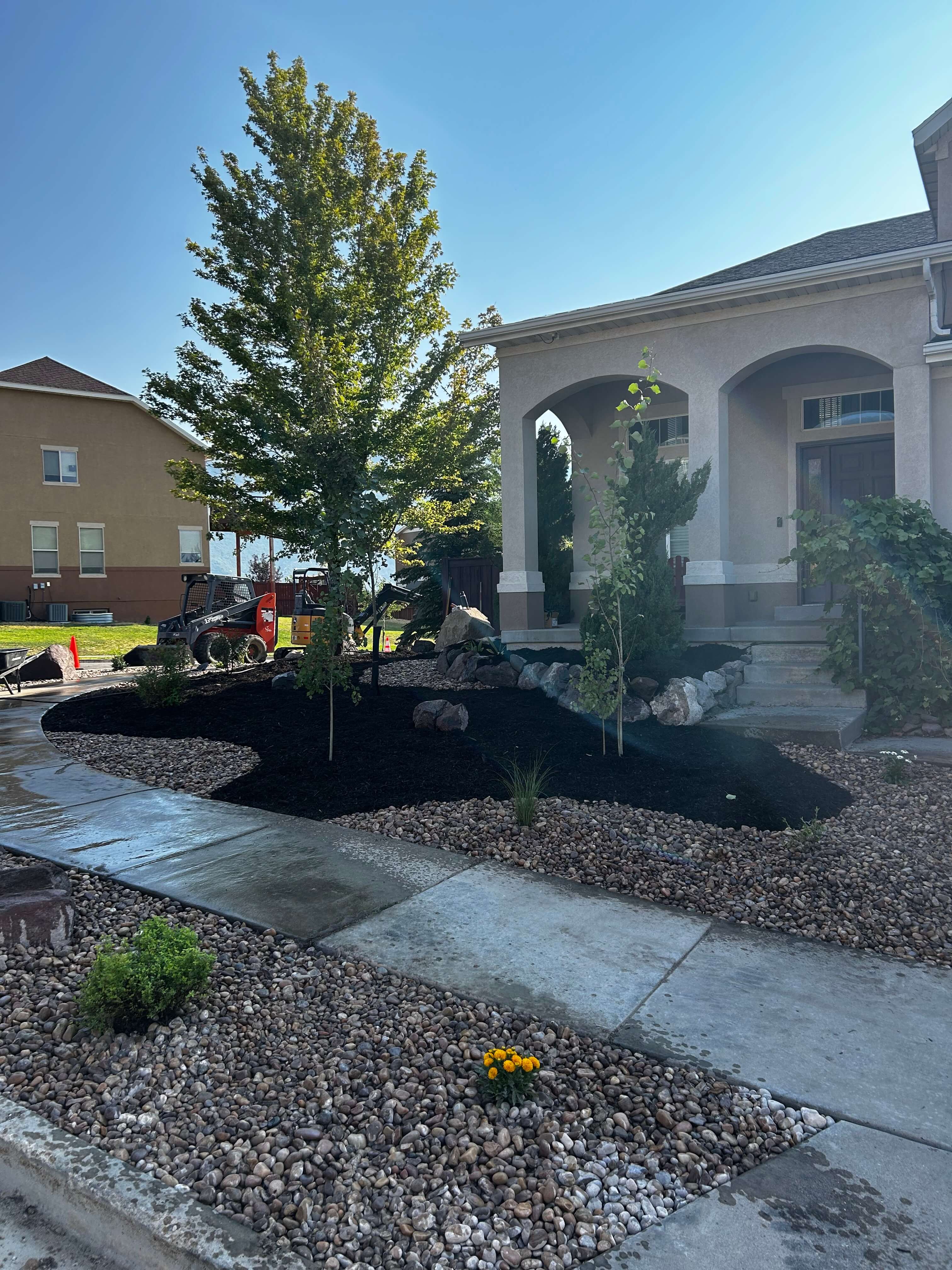 Complete landscaping installation with plants, hardscapes, and design elements